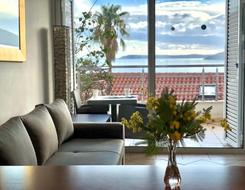 a living room with a couch and a vase of flowers at Boka Residence 7 in Herceg-Novi