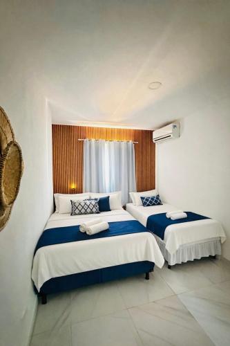 a bedroom with two beds with blue and white sheets at Pousada Doce Mar in Maragogi
