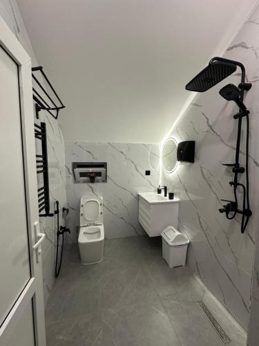 a white bathroom with a sink and a toilet at Gabala Central Villa in Gabala
