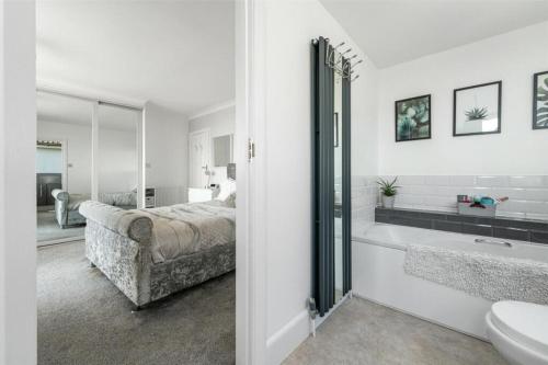 a bedroom with a bed and a tub and a sink at Ocean View in Worthing, 5 bedrooms for 10, 3 Bathrooms, Hot Tub, Parking for 6, Seaview in Sompting