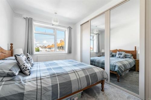 a bedroom with two beds and a window at Ocean View in Worthing, 5 bedrooms for 10, 3 Bathrooms, Hot Tub, Parking for 6, Seaview in Sompting