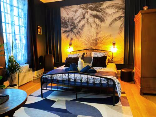a bedroom with a bed with a painting on the wall at Château des Bourdons Charme, Spa & Nature in Varennes Vauzelles