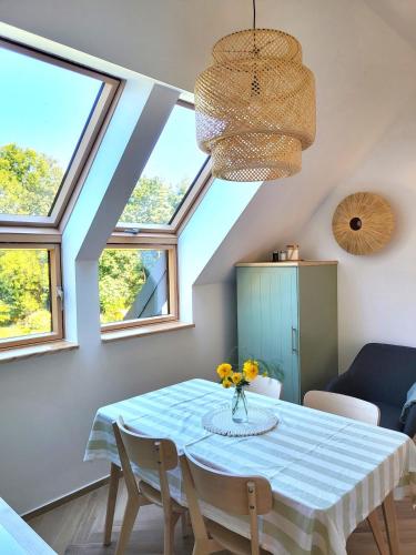 a dining room with a table and some windows at Slow Life Rabka in Rabka-Zdrój