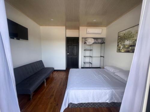 a small bedroom with a bed and a couch at Live bambu in Caimital