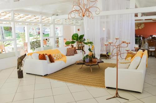a living room with two white couches and a table at Pousada Bucaneiro in Búzios