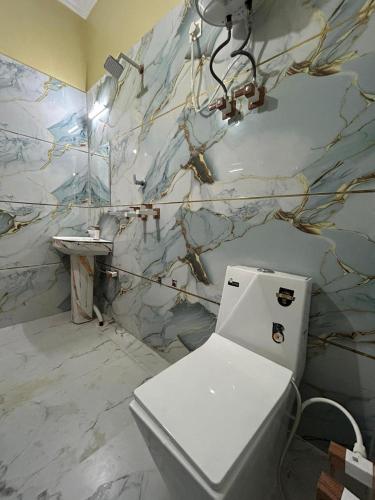 a bathroom with a white toilet and a sink at Prabhukripa Vilas Homestay in Mathura