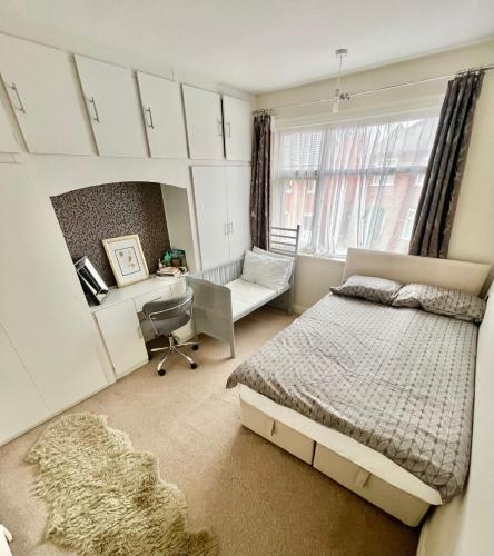 a bedroom with a bed and a desk and a chair at Cosy & comfortable home in the heart of Loughborough in Loughborough