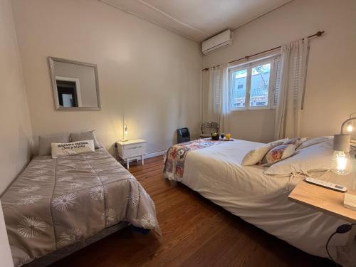 a bedroom with two beds and a desk and a window at Amplia casa en la 5ta sección ciudad con patio y parrilla in Mendoza