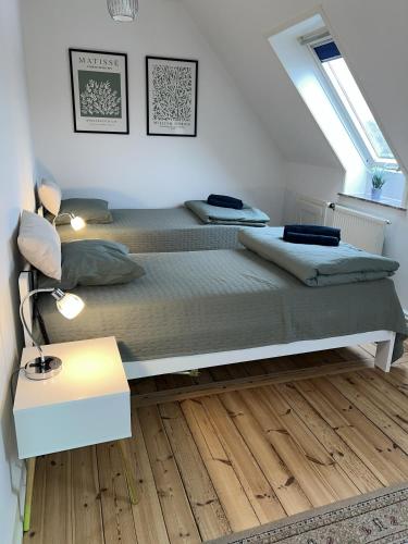 a bedroom with two beds and a table and a window at Flot byhus tæt på Lalandia og Femern in Rødby