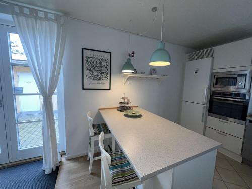 a kitchen with a white counter and a kitchen island at Flot byhus tæt på Lalandia og Femern in Rødby