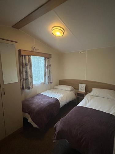 a hotel room with two beds and a window at Rowan 42 in New Milton