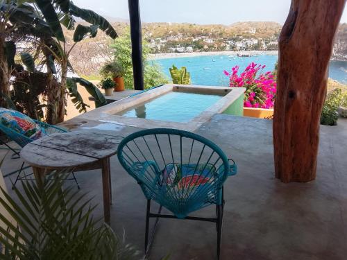 a patio with a table and chairs and a pool at Angelita's Nest House in Puerto Ángel