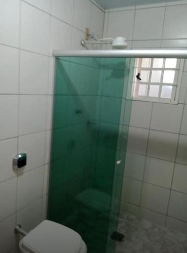 a bathroom with a glass shower with a toilet at Casa familiar in Vespasiano