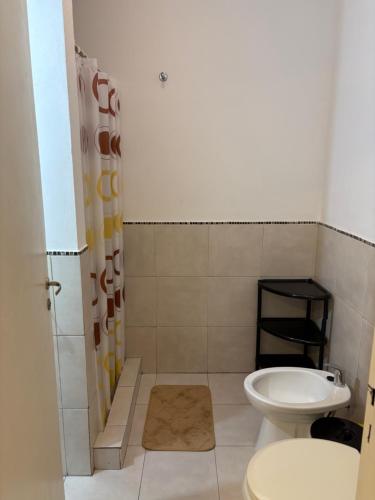 a bathroom with a toilet and a sink at Amelia 2-4 in Villa Carlos Paz