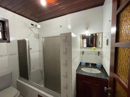 a bathroom with a shower and a sink and a toilet at Meu Point Gravatá 1 - Refúgio Familiar a 100 Metros do Mar in Saquarema