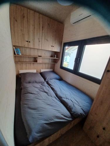 a bed in a small room with a window at Tiny Schwarzwald in Schopfloch