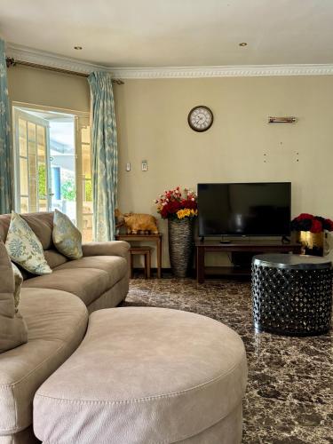 a living room with two couches and a flat screen tv at Annavilla7 Lilongwe hotel in Lilongwe