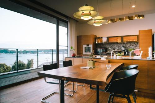 a kitchen and dining room with a wooden table and chairs at The House of Ocean in Nachikatsuura