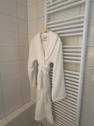 a white robe is hanging in a closet at L'Excelsior Suites in Brasschaat