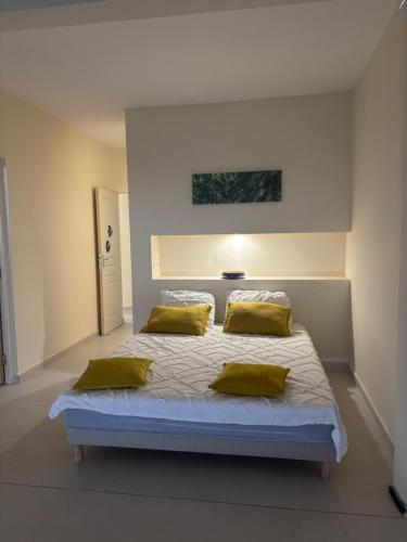 a bedroom with a large bed with yellow pillows at Villa exceptionnelle en bord de mer - SUNSET VILLA in Pointe-Noire