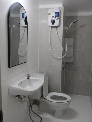 a bathroom with a shower and a toilet and a sink at Hi Impact Muangthong T9 in Nonthaburi