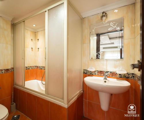 a bathroom with a sink and a mirror and a tub at Nilotique in Cairo