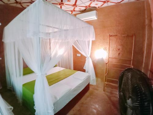 a bedroom with a bed with a canopy at Monkey Jungle Cottage in Udawalawe
