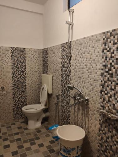 a bathroom with a toilet and a shower at Coralberry Inn in Jāmb