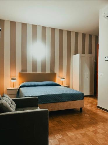a bedroom with a bed and a couch at Foresteria Tosi in San Colombano al Lambro
