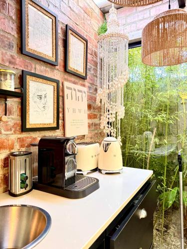 a kitchen counter with a microwave and a sink at The Secret Garden Hideaway in Mossel Bay