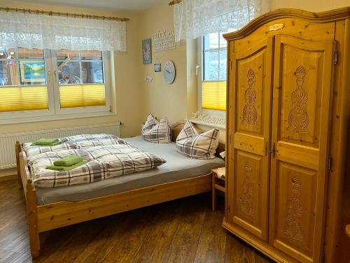 a bedroom with a bed and a wooden cabinet at Ferienwohnung Anna in Benneckenstein