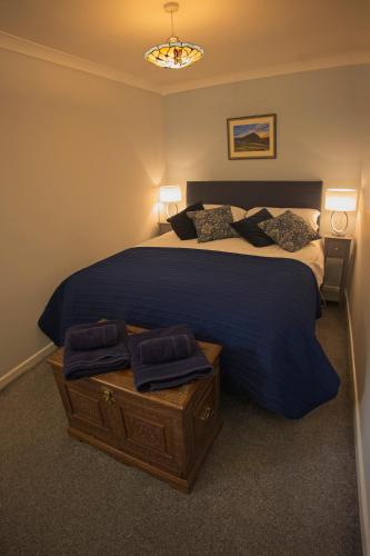 a bedroom with a large bed with a blue comforter at Ground floor well appointed cosy flat in Ludlow in Ludlow