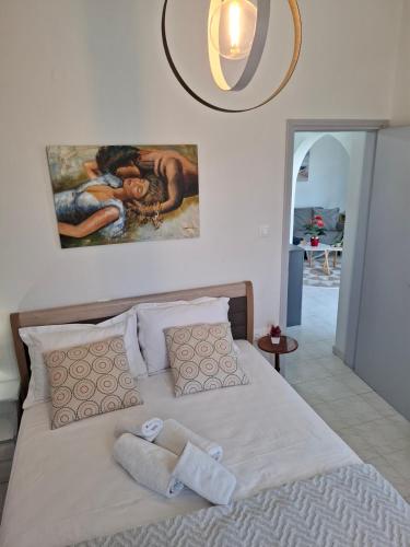 a bedroom with a bed with a painting on the wall at Κυκλαδίτικο σπίτι με θέα Villa Mimika in Perissa
