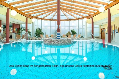 a large swimming pool with a fountain in the middle at Dünenhaus mit Schwimmbadnutzung in Göhren
