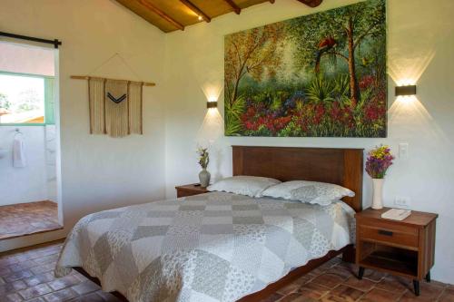 a bedroom with a bed and a painting on the wall at Trinitarios in Barichara