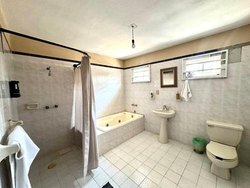 a bathroom with a tub and a toilet and a sink at Colimota in Colima