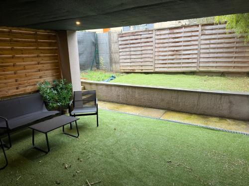a patio with a bench and a chair and a window at Jolie duplex face à la Seine in Villeneuve-le-Roi