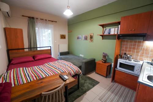a bedroom with a bed and a table and a kitchen at Marianna's studio in Kozani