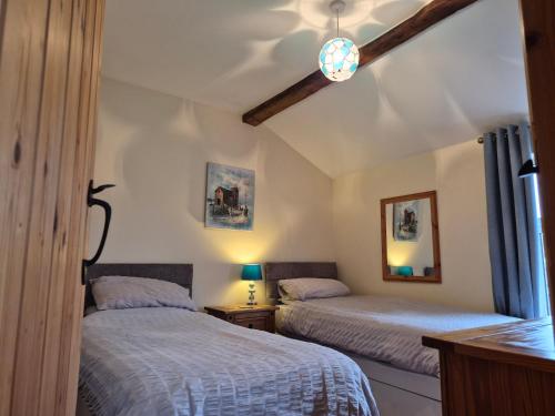 a bedroom with two beds and a ceiling at Coastline cottage Pakefield, 2 minutes walk to the beach in Pakefield