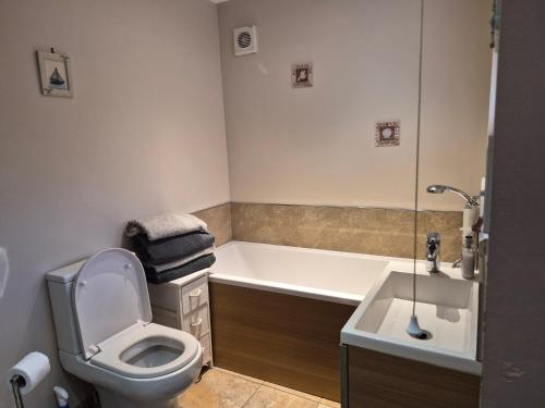 a bathroom with a toilet and a tub and a sink at Coastline cottage Pakefield, 2 minutes walk to the beach in Pakefield