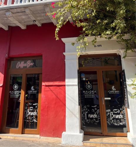 a red and white building with two glass doors at Maloka Boutique Centro Histórico in Cartagena de Indias