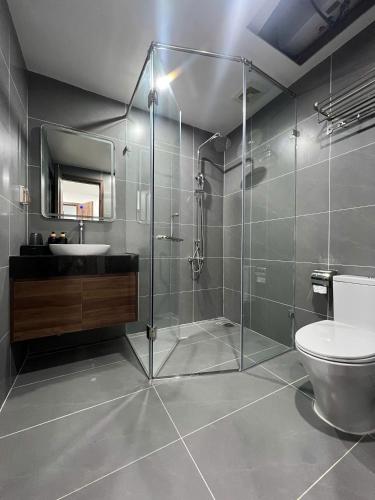 a bathroom with a shower and a toilet and a sink at Sora Hotel in Thường Son