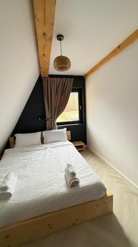 a bedroom with a large white bed with a window at La Salcami in Burzuc
