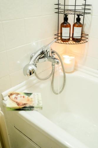 a bathroom sink with a faucet and a book on it at Chalupa pod vysokou in Ludvíkov
