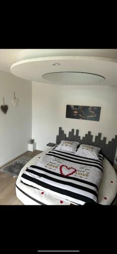 une chambre avec un lit avec une couette noire et blanche dans l'établissement Love room, à Gémozac