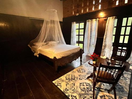 a bedroom with a bed with a mosquito net at Greenbay Beach Resort in Varkala