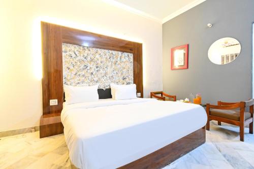 a bedroom with a large white bed with a window at FabHotel Classic Holidays in Jaipur
