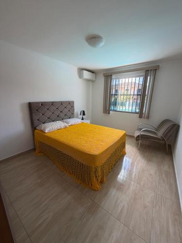a bedroom with a yellow bed and a window at Casa em Ipanema - Pontal do Paraná in Pontal do Paraná