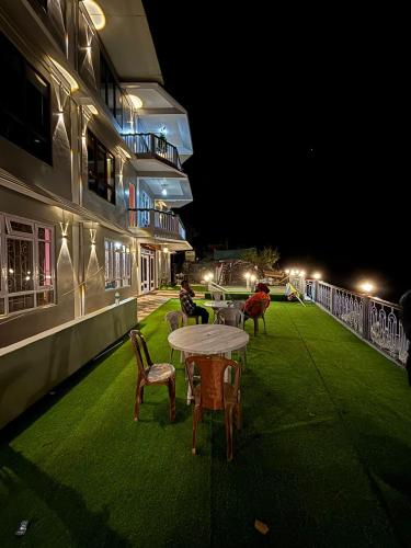 a patio with tables and chairs on a building at night at Hotel Sunrise in Sāmthar