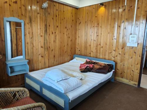 a bed in a room with wooden walls at Hotel Sunrise in Sāmthar